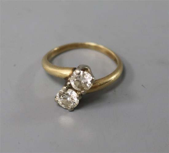 An 14ct gold and diamond two stone crossover ring, size L.
